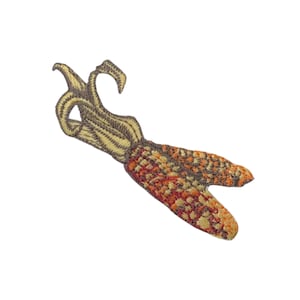 Może przedstawiać: Naszywka haftowana przedstawiająca kolbę kukurydzy z wciąż przymocowaną łuską, w odcieniach brązu, żółci i pomarańczy.