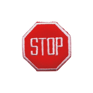 May include: A red, octagonal patch with the word "STOP" in white, block letters. The patch has a white stitched border. The design is reminiscent of a road sign.