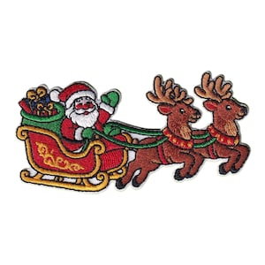 May include: An embroidered patch featuring Santa Claus in a red suit with a white beard, sitting in a red and gold sleigh filled with gifts, pulled by two brown reindeer with tan antlers and red collars against a white background.