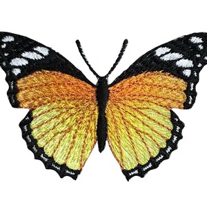 May include: Embroidered butterfly patch with a detailed design. The butterfly features yellow, orange, and black colors. The wings have a textured appearance, and the edges are outlined in black. The antennae are black.