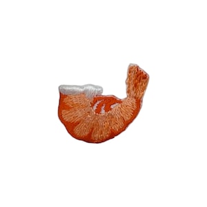 May include: Embroidered patch in the shape of a shrimp. The patch features orange and white thread, with detailed stitching to create the shrimp's form. The design is set against a white background.