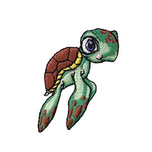 Puede incluir: Un parche bordado que representa una tortuga de mar de dibujos animados con ojos grandes. La tortuga está nadando con las aletas extendidas.