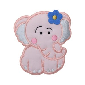 Puede incluir: Aplique de fieltro rosa en forma de elefante con una flor azul en la cabeza. El elefante tiene un cuerpo rosa claro, orejas blancas y una trompa rosa claro.
