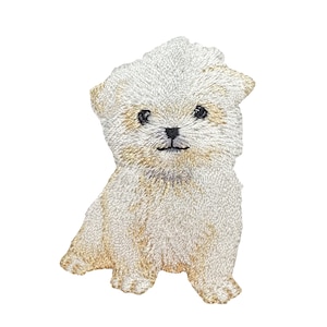 May include: Embroidered patch of a seated puppy with a fluffy, light beige coat. The puppy has black eyes and a black nose, with detailed stitching creating a textured appearance. The patch is designed to be ironed on or sewn onto fabric.