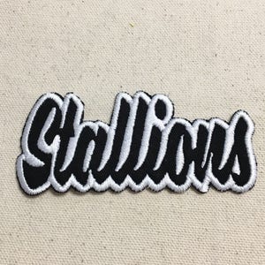 Puede incluir: Parche bordado en blanco y negro con la palabra "Stallion" en una fuente estilizada.