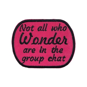 May include: A pink patch with black text that reads "Not all who Wonder are in the group chat." The patch has a black border and an oval shape.