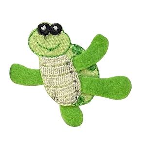 May include: A green felt turtle with a white shell and black eyes. The turtle has a smiling face and its arms and legs are outstretched.