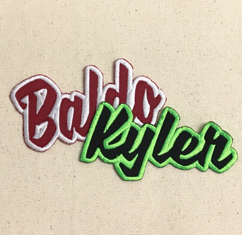 May include: Two embroidered patches with names. The first patch is red with white outline and says "Baldo". The second patch is green with black outline and says "Kyler".