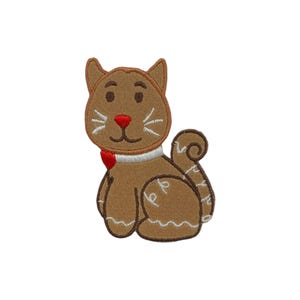 May include: A brown cat-shaped applique with a red nose and bow tie. The cat has white whiskers and a white collar. The tail is curled, and the applique is designed to be sewn onto fabric.
