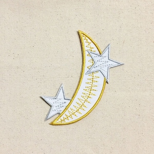May include: A white crescent moon with a gold outline and two white stars with a gold outline.