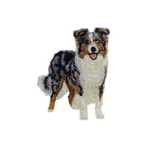 Peut inclure: Écusson brodé d'un chien Berger Australien. Le patch présente un design détaillé avec une palette de couleurs blanche, noire, marron et beige. Le chien est représenté debout, la langue légèrement visible.