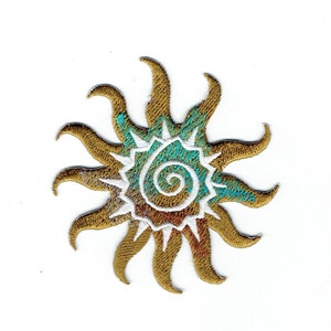 May include: Gold embroidered sun with a turquoise and white spiral design in the centre.