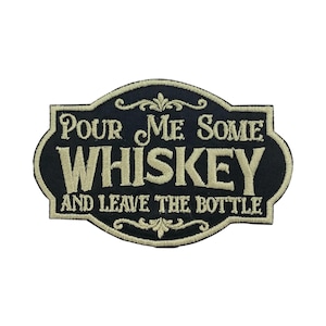 May include: Black embroidered patch with the text "Pour Me Some Whiskey And Leave The Bottle" in a decorative font. The patch has a black background with gold-colored lettering and decorative flourishes.