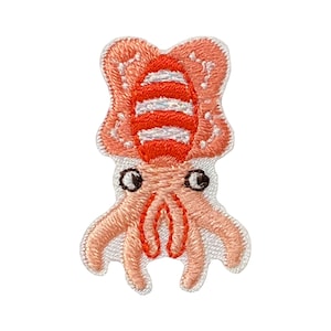May include: An embroidered iron-on patch of a pink squid with red and white stripes on its head. The squid has large black eyes and a friendly expression.