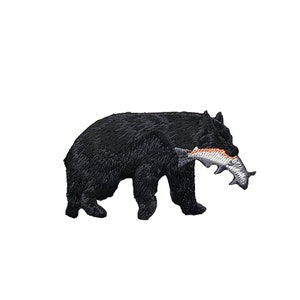 May include: Black bear with a fish in its mouth. The bear is walking to the right. The fish is orange and white.