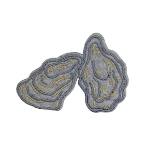 May include: A gray felt patch with a gold embroidered design of two oyster shells.