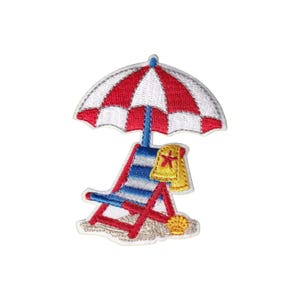 May include: Embroidered patch featuring a beach scene. A red and white striped umbrella shades a blue and red striped beach chair. A yellow towel with a star design hangs on the chair. A seashell rests on the sand.