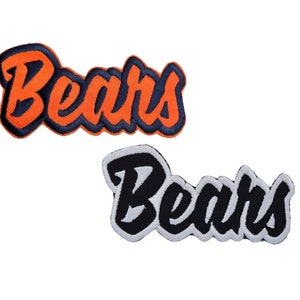 May include: Two embroidered patches with the word "Bears" in a stylised font. The top patch is orange with black outlining, and the bottom patch is black with white outlining.