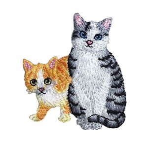 May include: Embroidered patch featuring two cats. The larger cat is gray and white with black stripes and blue eyes. The smaller cat is orange and white with yellow eyes. Both cats are looking at the viewer.