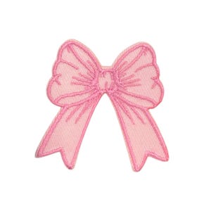 May include: A pink fabric bow with a detailed embroidered design. The bow is a decorative embellishment for crafts and sewing projects.