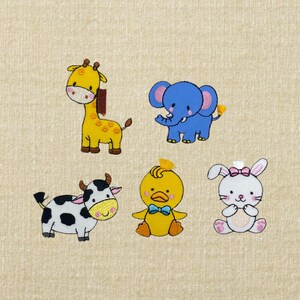 May include: Embroidered animal designs including a yellow giraffe with brown spots, a blue elephant, a black and white cow, a yellow duck with a blue bow tie, and a white bunny with a pink bow. The designs are on a beige background.