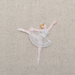 May include: White embroidered ballerina applique with a pink tutu and gold crown. The ballerina is in a dancing pose with one leg extended.