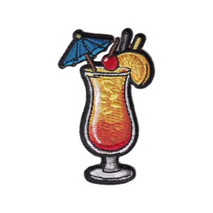 Op de afbeelding: Geborduurde patch met een cocktail met een blauwe paraplu, kers en sinaasappelschijfje. De drank zit in een hoog glas met een rode en gele gradiënt. De patch heeft een zwarte rand.