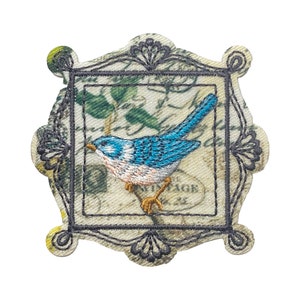May include: Embroidered patch featuring a blue bird in a vintage-style frame with a floral background. The frame has a black outline and intricate details.