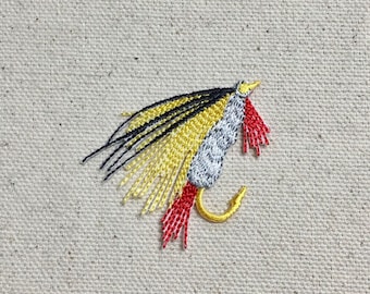 May include: A close-up of a black, yellow, and red fishing lure with a silver hook.