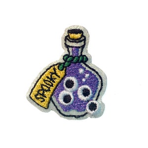 May include: Embroidered iron-on patch of a purple potion bottle with a tag that says "Spooky" and white eyeballs floating inside.