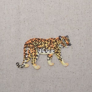 May include: Embroidered patch of a brown and orange leopard walking to the right. The leopard has black spots and stripes.