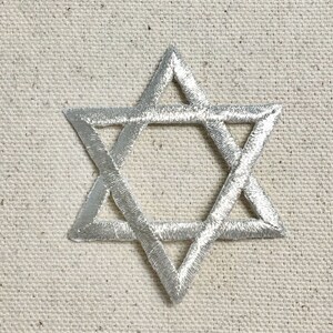 以下が含まれることがあります： 銀色の刺繍が施されたダビデの星のワッペン。ワッペンは、6つのポイントを持つ星で、その中にさらに小さな6つのポイントを持つ星が入っています。