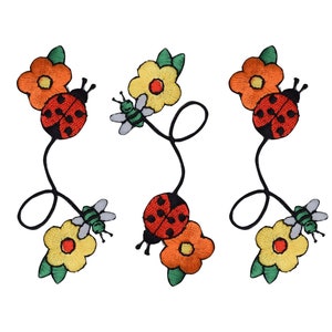 Puede incluir: Tres parches bordados para planchar que representan mariquitas, abejas y flores. Los parches son en tonos de rojo, naranja, amarillo, verde y negro.