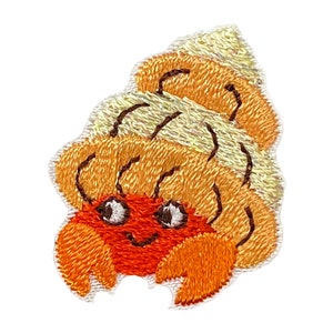 May include: Embroidered patch of a cartoon hermit crab with a brown shell and orange body. The crab has large eyes and a smiling mouth.