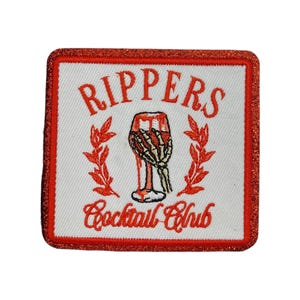 Rippers Cocktail Club Embroidered Iron-On Patch – Orange Glitter Border, Retro Halloween Skeleton Hand