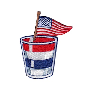 May include: Embroidered patch featuring a patriotic design. The patch depicts a red, white, and blue cocktail glass with an American flag waving above it. The glass has a white outline and is filled with red and blue layers.