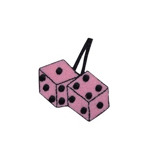 May include: Two pink dice with black dots hanging from a black string. The dice are a popular car accessory.