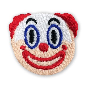Könnte beinhalten: Gestickter Bügelaufkleber mit einem lächelnden Clown-Gesicht mit roten Haaren, blauen Augen und einem roten Lächeln.