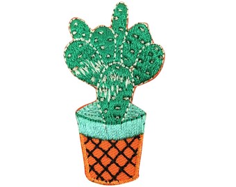 Könnte beinhalten: Gestickte grüne Kaktuspflanze in einem blauen und orangefarbenen Topf. Der Kaktus hat ein strukturiertes Design und ist ein beliebtes Dekorationsobjekt für zu Hause.