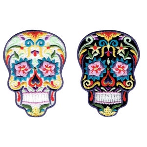 Peut inclure: Deux patchs brodés de crânes de sucre, l'un blanc avec des détails floraux colorés et l'autre noir avec des détails floraux colorés.