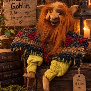 May include: A goblin figurine with long orange hair, pointed ears, and a textured face. It wears a multi-coloured woven poncho with red, blue, and brown threads over yellow fabric trousers. A brown tag attached to the poncho reads One of a kind.