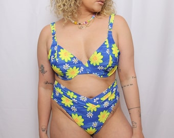 May include: A blue and yellow floral print bikini top and high-waisted bikini bottom.