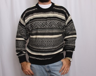 May include: A black and white striped sweater with a geometric pattern. The sweater has long sleeves and a crew neck.
