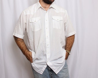 May include: A white short-sleeved button-down shirt with two chest pockets and a pointed collar.