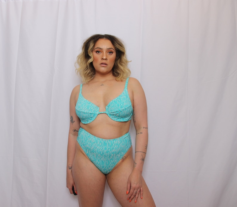 Puede incluir: Un top de bikini y una braga de bikini de cintura alta con estampado turquesa y blanco.