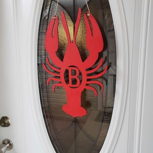 May include: Red wooden lobster door hanger with the letter "B" in the center.