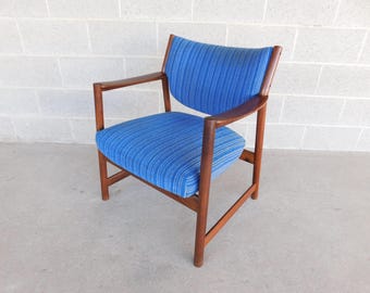 May include: Mid-century modern armchair with a blue and white striped seat and backrest. The chair has a wooden frame and armrests. The design is simple and elegant, suitable for a living room or office space.