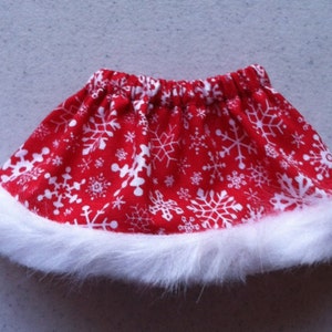 May include: A red skirt with a white snowflake pattern and a white fur trim.