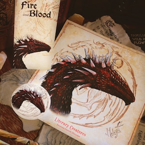May include: A close-up of a red dragon illustration with a spiky back and a detailed head. The illustration is on a beige background with a circular design. The text "Literary Creatures" and "Francesca Paiorchi Illustrator" is at the bottom of the image. The text "Meleys" is in the lower right corner of the image.