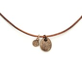 The rough one bronze beach stone on leather cord with bronze clasp